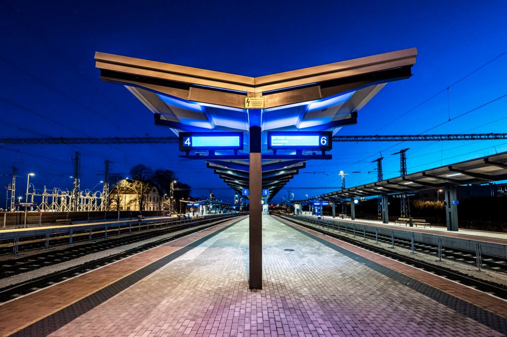 A train station with symmetrical passenger information displays about arriving trains.